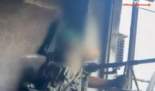 Imagen borrosa de un francotirador apuntando un rifle.