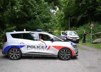 Los autos de la policía están estacionados frente a un área acordonada, cerca de un campo deportivo donde un hombre de 32 años fue encontrado muerto con la garganta de la garganta y destripado, en Pont-de-Metz el 4 de agosto de 2025. La víctima tenía heridas de puñalada en el cuello y la espalda y fue encontrado por un caminante en una posición cruzada, dijo la policía a la AFP. (Foto de Francois Nascimbeni / AFP) (Foto de Francois Nascimbeni / AFP a través de Getty Images)