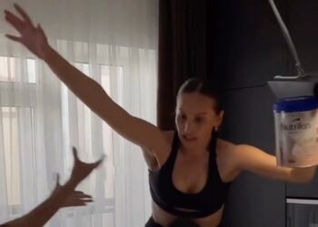 Mujer intentando un desafío de zapatos de tacón alto, cayendo.