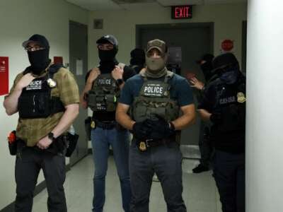 Los oficiales federales que usan revestimientos faciales esperan en un pasillo fuera de una sala del tribunal en el Tribunal Federal de Inmigración de la Plaza de Nueva York dentro del Edificio Federal Jacob K. Javitz en Nueva York.