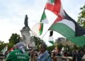 Un hombre sostiene las banderas argelinas (L), libanesas (superiores) y palestinas durante una manifestación pro-palestina contra las acciones de Israel y la hambruna en curso en la Franja de Gaza, y para dar la bienvenida a los activistas liberados de la Liberación de la Freedom Flotilla en el lugar de la République en París, Francia, el 29 de julio de 2025.