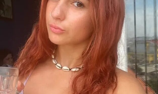 Mujer con cabello rojo en un balcón, disfrutando de un café durante su tiempo enseñando inglés en Vietnam.