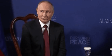 Vladimir Putin sentado en una mesa.
