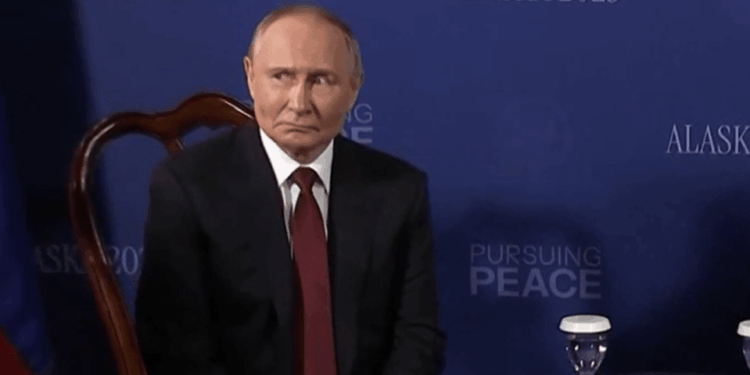Vladimir Putin sentado en una mesa.