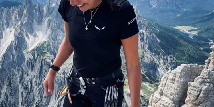 Mujer sonriendo en una cumbre de montaña.