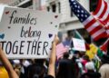Un manifestante lleva un letrero que lee 'Las familias pertenecen juntas' en Los Ángeles, California.