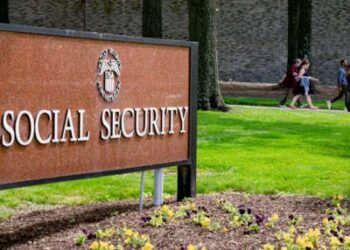 Los trabajadores de la Administración del Seguro Social pasan el letrero de la agencia frente a la sede en Woodlawn, Maryland, el 20 de mayo de 2025.