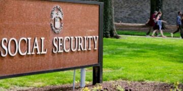 Los trabajadores de la Administración del Seguro Social pasan el letrero de la agencia frente a la sede en Woodlawn, Maryland, el 20 de mayo de 2025.