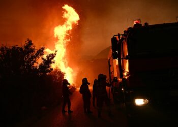 Los bomberos que luchan contra un incendio forestal por la noche.