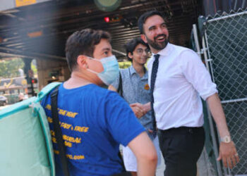 El candidato a la alcaldía de Nueva York y representante estatal Zohran Mamdani saluda a los votantes con el candidato demócrata a la alcaldía Michael Blake en la calle 161 el 24 de junio de 2025, en el South Bronx en la ciudad de Nueva York