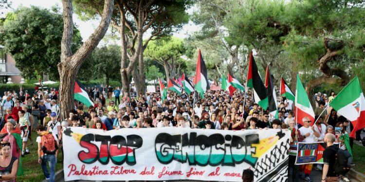 Protesta pro-palestina con lectura de banner "Detener el genocidio."