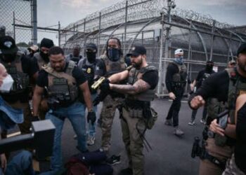 Un agente federal amenaza con los manifestantes de Taser durante una protesta en el centro de detención de Delaney Hall.