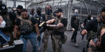 Un agente federal amenaza con los manifestantes de Taser durante una protesta en el centro de detención de Delaney Hall.