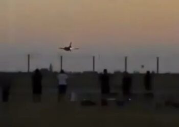 Atrenamiento en avión al atardecer con gente observando.