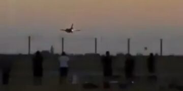 Atrenamiento en avión al atardecer con gente observando.