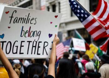 Un manifestante lleva un letrero que lee 'Las familias pertenecen juntas' en Los Ángeles, California.