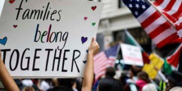 Un manifestante lleva un letrero que lee 'Las familias pertenecen juntas' en Los Ángeles, California.