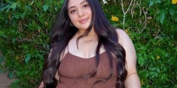 Mujer y niño pequeño posando con una canasta de flores.