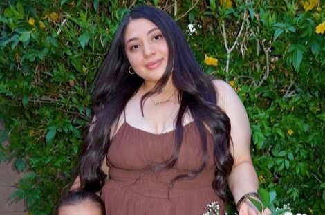 Mujer y niño pequeño posando con una canasta de flores.