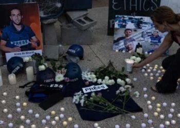 La gente sostiene fotos, pone flores y velas ligeras durante una vigilia fuera de la sede de Fox News y NBC News en Washington, DC, el 11 de agosto de 2025, en honor a periodistas asesinados en Gaza, incluidos Anas al-Sharif y sus colegas.