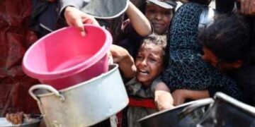 Los palestinos se reúnen para recibir comidas cocinadas de un centro de distribución de alimentos en la ciudad de Gaza, Palestina, el 15 de agosto de 2025. Nueva legislación israelí que regula a los grupos de ayuda extranjera niega cada vez más sus solicitudes de traer suministros a Gaza, una carta conjunta firmada por más de 100 grupos dice.