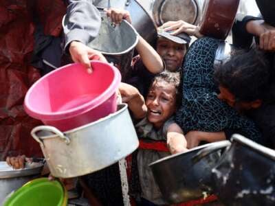 Los palestinos se reúnen para recibir comidas cocinadas de un centro de distribución de alimentos en la ciudad de Gaza, Palestina, el 15 de agosto de 2025. Nueva legislación israelí que regula a los grupos de ayuda extranjera niega cada vez más sus solicitudes de traer suministros a Gaza, una carta conjunta firmada por más de 100 grupos dice.