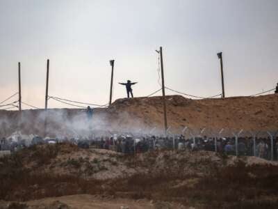 Miembros de una empresa privada de seguridad estadounidense, contratada por la Fundación Humanitaria de Gaza (GHF), palestinos desplazados directos mientras se reúnen para recibir suministros de ayuda en un centro de distribución en la Franja Central de Gaza el 8 de junio de 2025, ya que las tropas israelíes disparan bombas de humo.