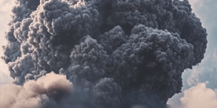 Gran columna de humo oscuro en erupción.