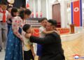 Kim Jong Un abrazando a los hijos de soldados caídos en una ceremonia de premiación.
