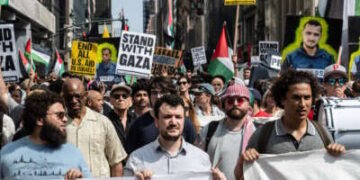 Un grupo de manifestantes dirigidos por Mahmoud Khalil Hold Signs que decían "Stand with Gaza" en la ciudad de Nueva York