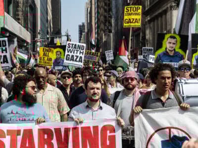Un grupo de manifestantes dirigidos por Mahmoud Khalil Hold Signs que decían "Stand with Gaza" en la ciudad de Nueva York