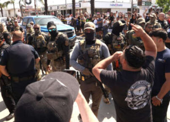 Los residentes se enfrentan a los agentes de la Patrulla Federal y Fronteriza por una redada en su vecindario en Atlantic Blvd. en la ciudad de Bell, California, el 19 de junio de 2025.