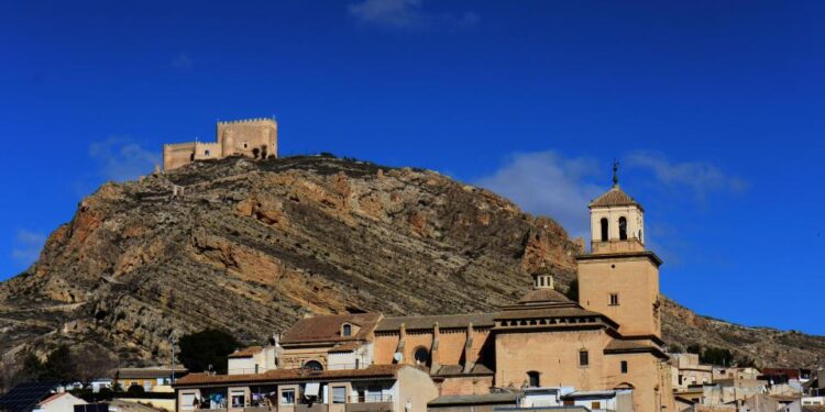 Castillo de Jumilla Castle sobre una colina con vistas a una ciudad.