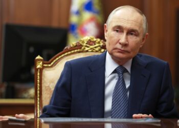 Vladimir Putin sentado en una mesa.