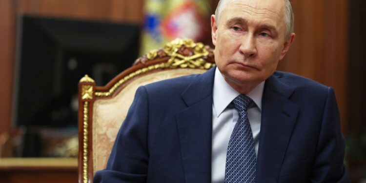 Vladimir Putin sentado en una mesa.