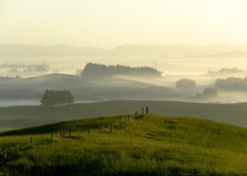 Misty Sunrise sobre colinas y tierras de cultivo.
