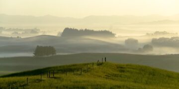 Misty Sunrise sobre colinas y tierras de cultivo.