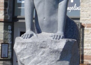 Estatua de una sirena sentada en una roca.