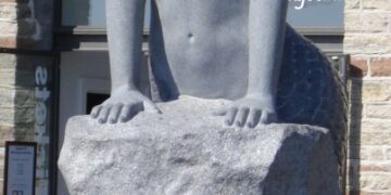 Estatua de una sirena sentada en una roca.