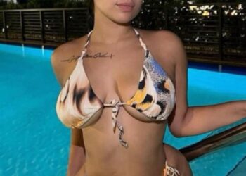 Foto de Lina Bina, también conocida como Missjohndough, por una piscina por la noche.