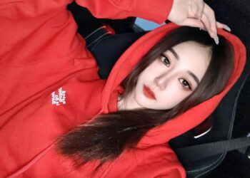 Foto de Irene Gu, una influencia taiwanesa, en una sudadera con capucha roja.