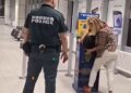 Una mujer lucha por encajar su bolso en un Sizer de equipaje de Ryanair mientras un oficial de policía fronteriza observa.