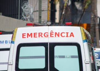 Parte de una ambulancia con "Emergência" escrito en él.
