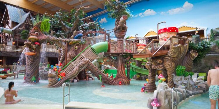 Área de juego acuático infantil con esculturas caprichosas de árboles y hongos.