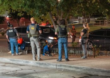 Los oficiales de policía del FBI, ATF y el Parque de los Estados Unidos ayudan a una mujer que experimenta aparentes efectos secundarios sintéticos de marihuana.