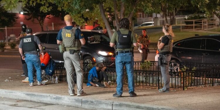 Los oficiales de policía del FBI, ATF y el Parque de los Estados Unidos ayudan a una mujer que experimenta aparentes efectos secundarios sintéticos de marihuana.