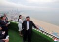 Kim Jong Un y su hija con vista a una playa desde un balcón.
