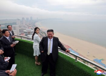 Kim Jong Un y su hija con vista a una playa desde un balcón.