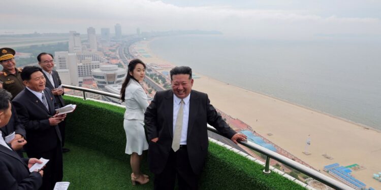 Kim Jong Un y su hija con vista a una playa desde un balcón.