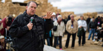 El ex gobernador de Arkansas, Mike Huckabee, es visto cuando pronuncia un discurso a un grupo de turistas y peregrinos cristianos evangélicos estadounidenses durante una visita a la antigua fortaleza de Masada en el desierto judeo en Israel, el 19 de febrero de 2015.